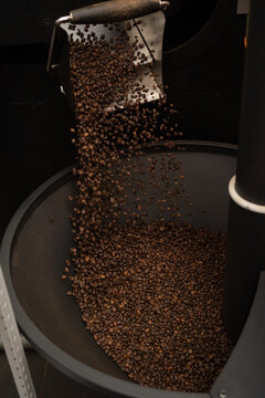 Roasted coffee beans falling into cooling container