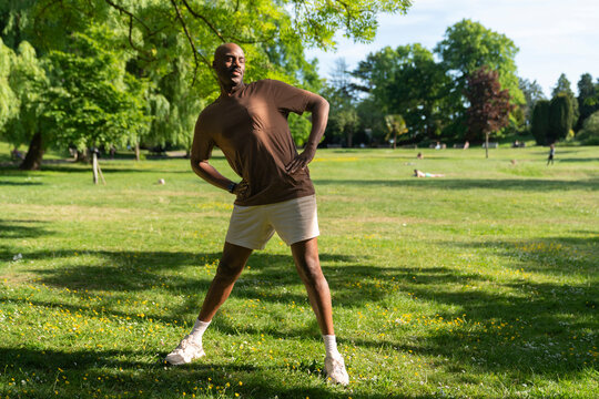 Black man Smiling while warming up for his Yoga session in a Park