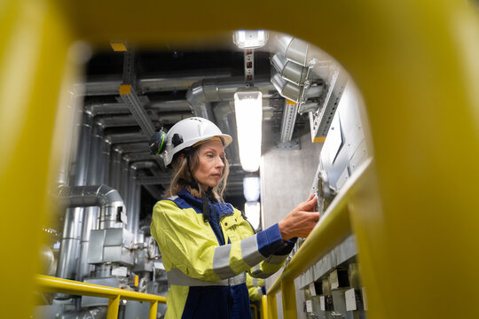 Female Engineer Operating Machinery in Power Plant