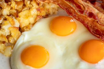 fried eggs and bacon and hash browns, detail