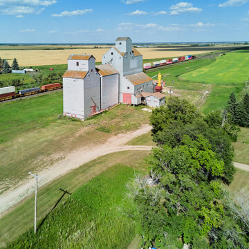 Drone view of grain elevator and freight train in Saskatchewan prairie