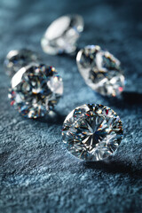 Close-up of cut diamonds on textured surface, showcasing their brilliance.