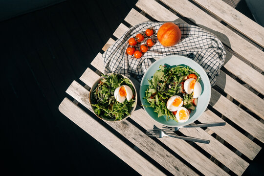 Fresh Salad With Eggs and Cherry Tomatoes on a Sunny Table