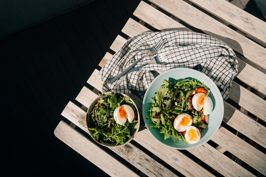 Fresh Salad With Eggs and Cherry Tomatoes on a Sunny Table