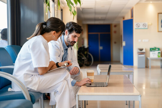 Doctors working on laptop and discussing patient chart