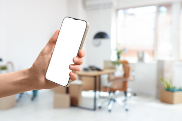 Blurred view of office with workplace, plants and cardboard boxes on moving day