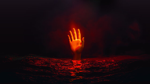 Red hand reaching for help in dark water during Halloween night