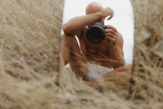 Man Taking a Self-Portrait in a Field With Tall Grass