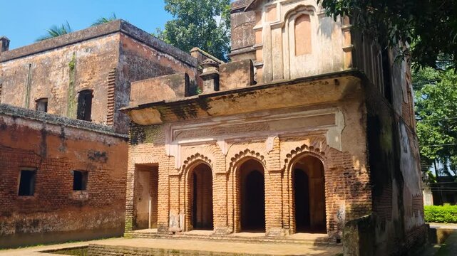 An old brick colonial mansion stands in sunlight amid the abandoned ghost town of Panam Nagar in Sonargaon, Bangladesh, echoing the forgotten grandeur of a bygone era