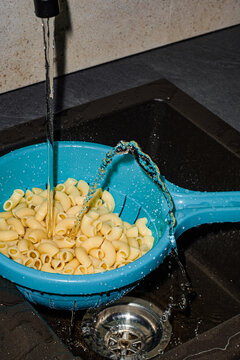 Everyday kitchen routine with funny water stream rinsing pasta