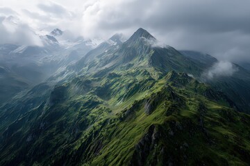 Aerial View of Mountain Range Under Cloudy Skies with Green Vegetation and White Snow Patches