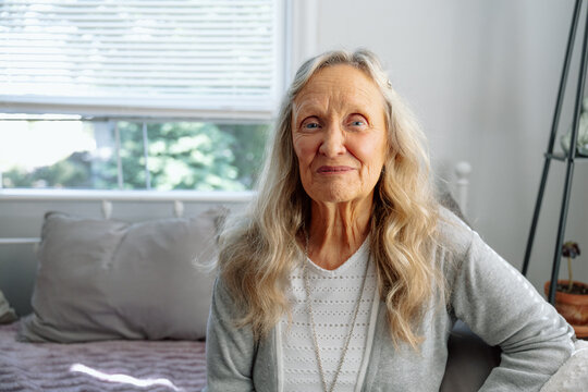 Elderly woman sitting indoors expressing contentment and wisdom 