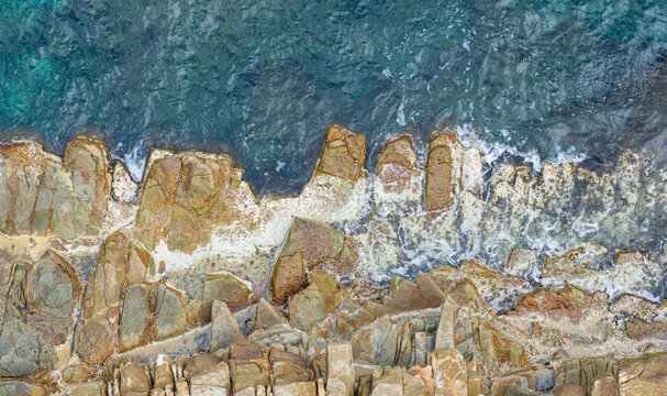 Aerial View of Hexagonal Basalt Cliffs Meeting Ocean Waves