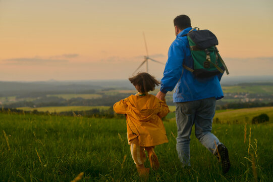 Father and Son Walking Through Meadow at Sunset