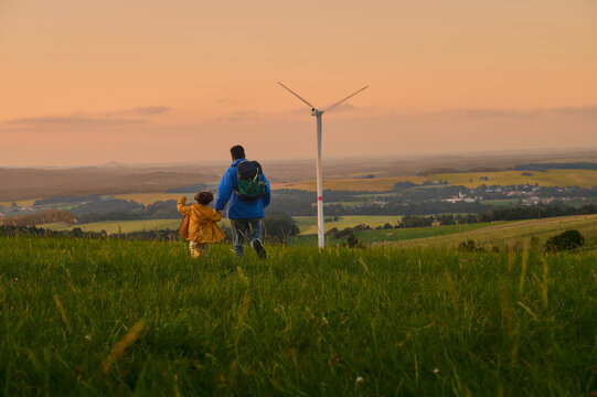 Father and Son Walking Through Meadow at Sunset