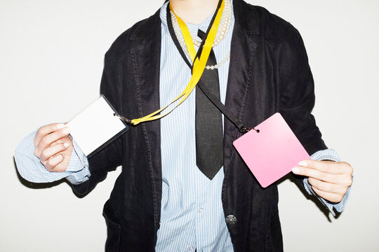 Person wearing suit & tie and holding business conference event badge