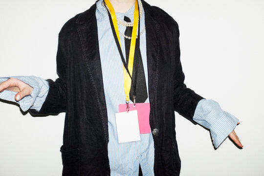 Person wearing suit & tie and holding business conference event badge