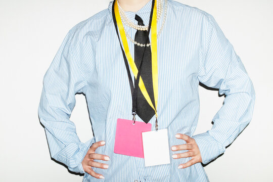 Person wearing suit & tie and holding business conference event badge