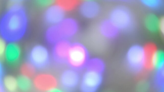 multicolored lights from christmas garland flickering softly, creating beautiful and festive abstract bokeh effect, perfect for holiday themed backgrounds and celebratory concepts. close up.