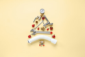 Christmas tree made of plumber's supplies with balls on beige background