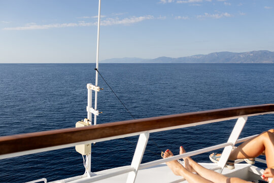 Anonymous women relaxing aboard ferry deck in sunlight