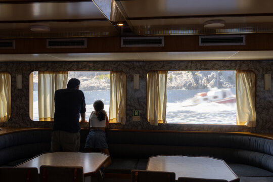 Father and daughter approaching island from indoor ferry