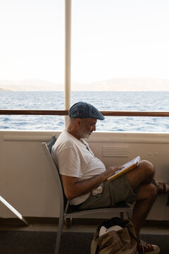 Tourist on ferry deck reading a comic