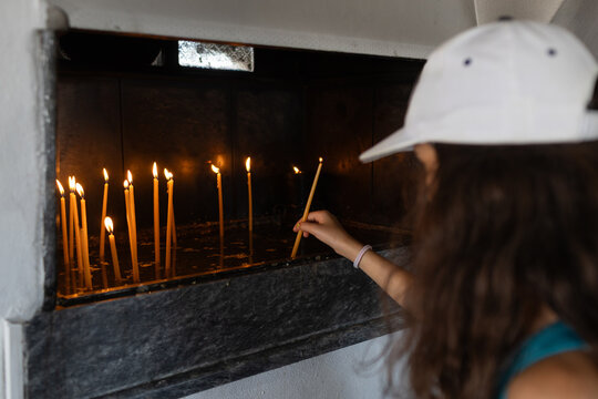 Tourist lighting candles in Greek Church 