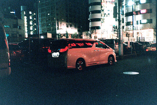 White van with red lettering reflected on the side at night