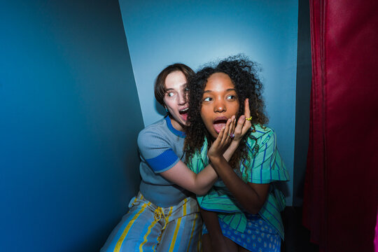 Surprised friends posing inside a photo booth