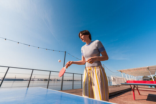 Focused person playing ping pong outdoors