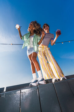 Friends holding drinks under string lights outdoors