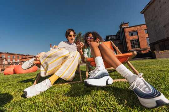 Friends sitting on deck chairs with phone