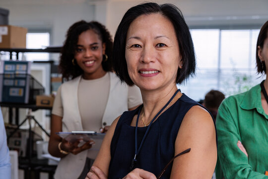 Diverse businesswomen smiling in an office setting.