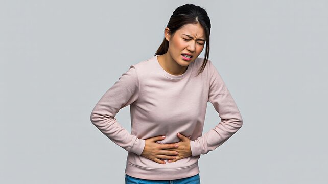 Woman suffering from stomach pain and discomfort on gray background
