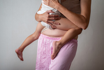 faceless Woman with a scar from a cesarean section holds a child