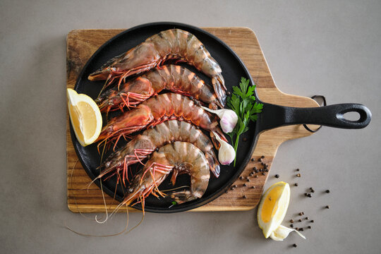 Fresh Tiger Prawns on Cast Iron Pan With Lemon and Herbs Aromatically