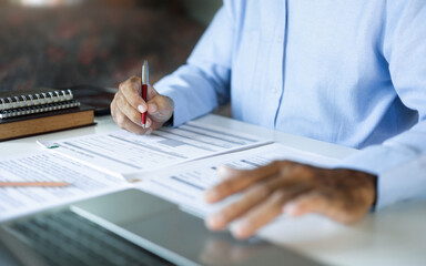 Fototapeta premium asian businessman, legal expert, professional lawyer working with laptop reviewing document and business contract before provide legal advice to clients, close up shot