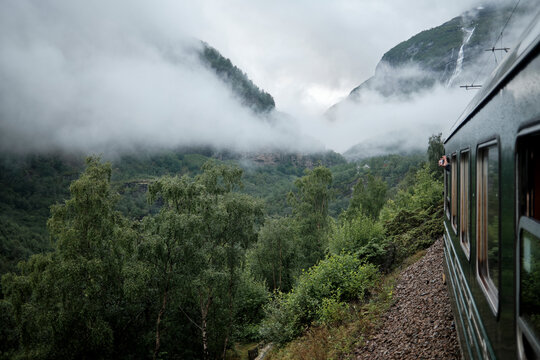 Fototapeta Scenic Train Ride Through Foggy Forest and Mountainous Landscape 