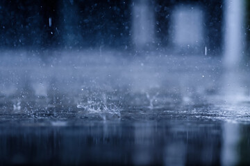 heavy raining make many small splash crown from water droplets drop down to the concrete floor in blue tone color scene