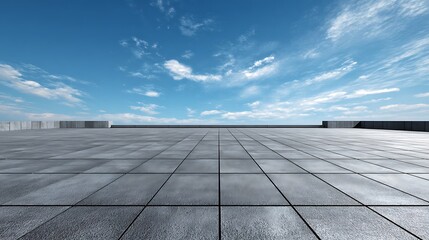 Empty concrete plaza under a vast blue sky with scattered clouds.