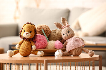 Knitted toys  with yarn and crochet hook on coffee table at home