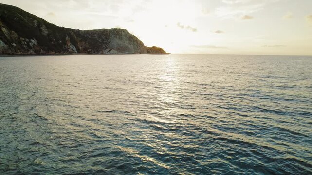Golden hour sunset over a rocky coastline on Kefalonia island in Greece during summer