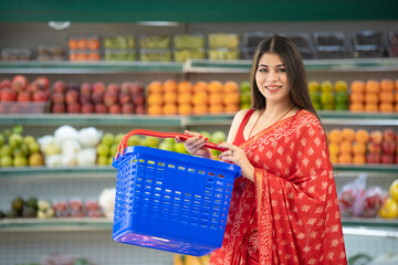 Indian woman giving happy expression while purchasing fresh fruit at super shop