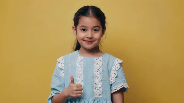 Little girl thumbs up and smiles
