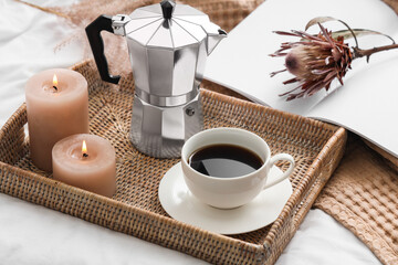 Cup of espresso with geyser coffee maker, candles and flower on bed, closeup