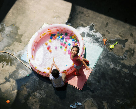 Asian children playing in the open air in a courtyard at a house