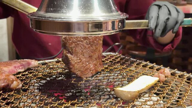 Chef Grilling Wagyu Steak Over Charcoal at Korean BBQ Restaurant