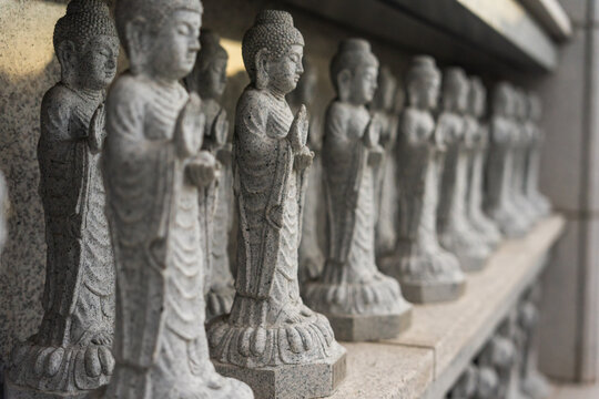 Rows of Intricately Carved Stone Buddha Statues Stand on a Shelf