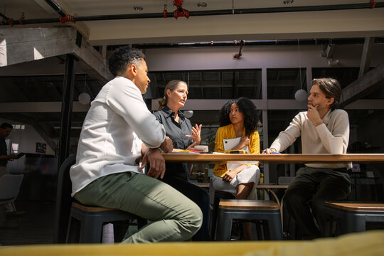 Coworkers having a meeting in a modern office with daylight
